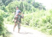 Jalin Kedekatan, Satgas TMMD Gendong Anak Kecil Pulang ke Rumahnya